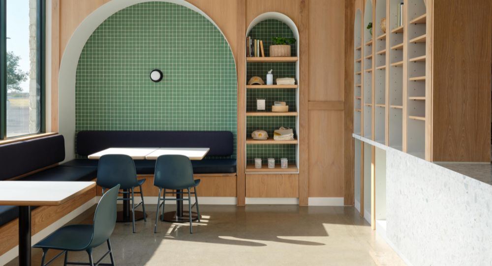 Dining room with a green-tiled arched booth, a lit niche of shelves and wood-paneled walls
